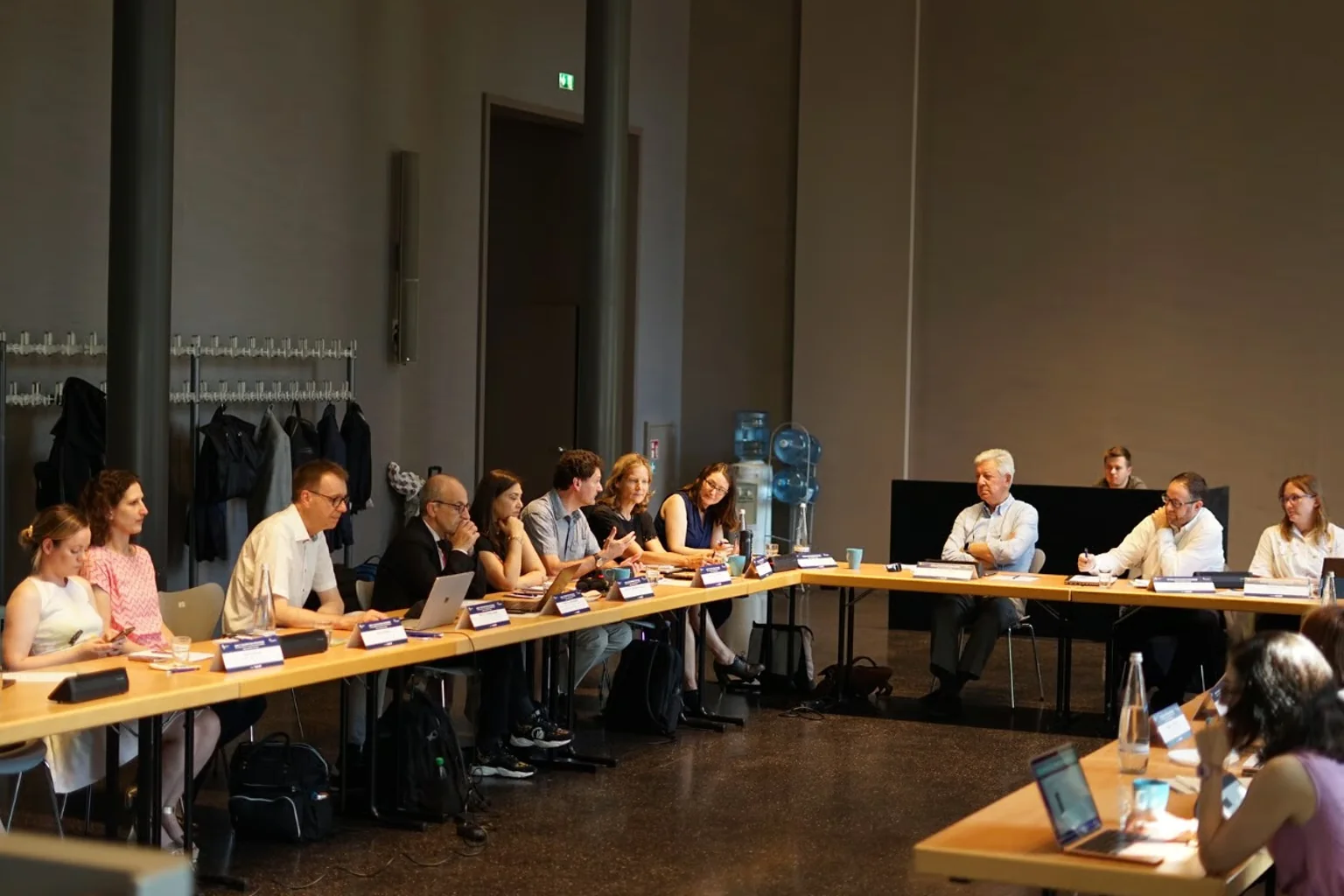 Directivos y líderes sectoriales sentados en mesa de trabajo durante un Bamberg Dialogues Forum, en sesión de capacidad reducida con debate abierto bajo Regla Chatham House