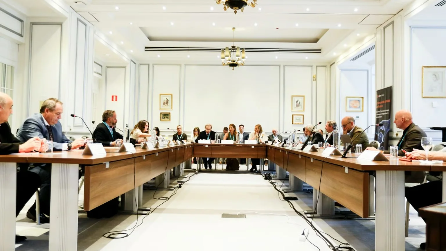 Vista general de una sala de sesiones de un Bamberg Dialogues Forum con participantes en disposición de mesa de trabajo para debate estratégico de alto nivel entre líderes del sector público y privado